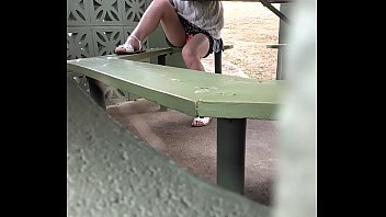 Girl rubs pussy under table in public park